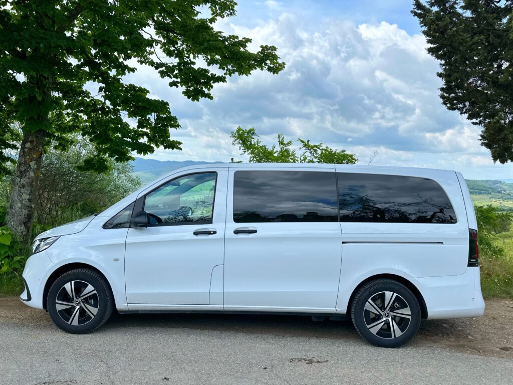 Mercedes van on a Tuscany vineyard tour from Florence through the Val d’Orcia towards Montalcino, showcasing rolling hills and cypress-lined roads