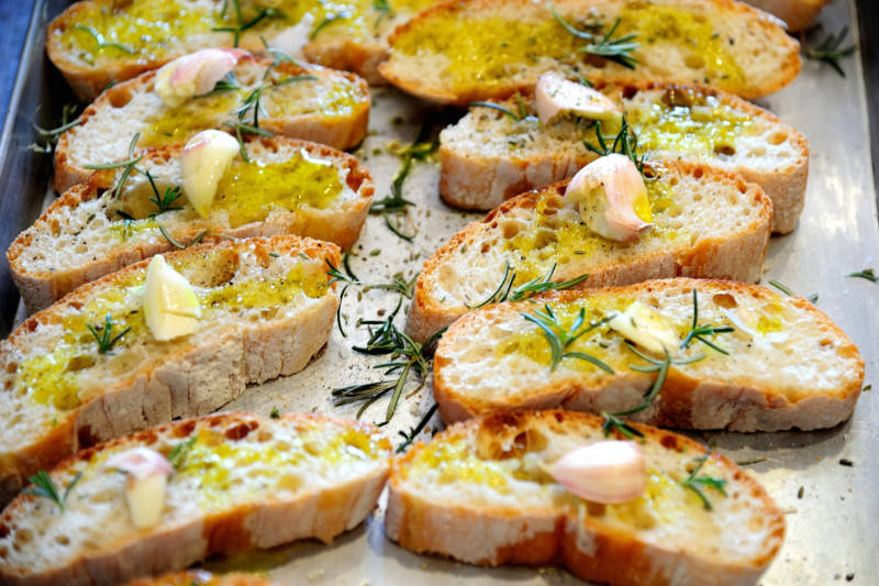 Close-up of fettunta: grilled Tuscan bread drenched in bright-green olio nuovo, November in Tuscany