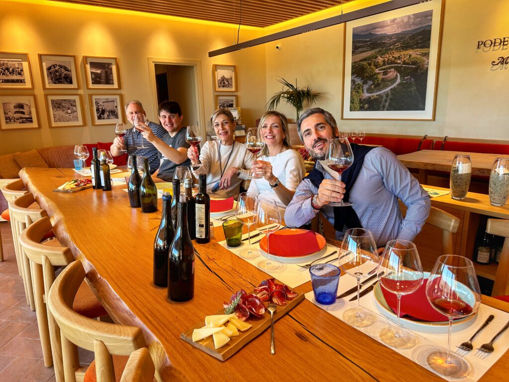 Guests toasting during a private Tuscany wine tour from Florence, celebrating a vineyard tasting experience in the Tuscan countryside.