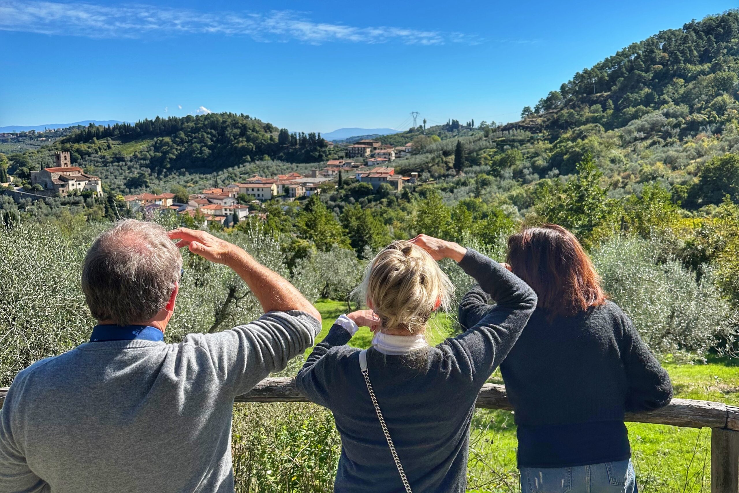 Travelers looking out over the Tuscan countryside on a wine tour from Florence, taking in the vineyard landscape.
