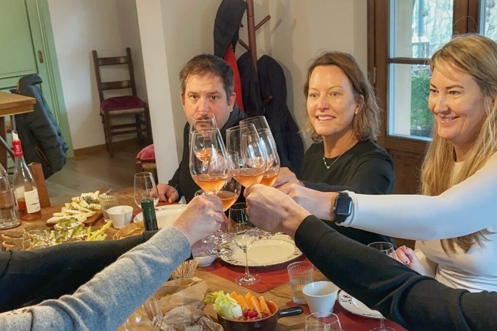 Guests toasting at the table during a Tuscany wine tour from Florence, enjoying a relaxed lunch and tasting in the countryside.