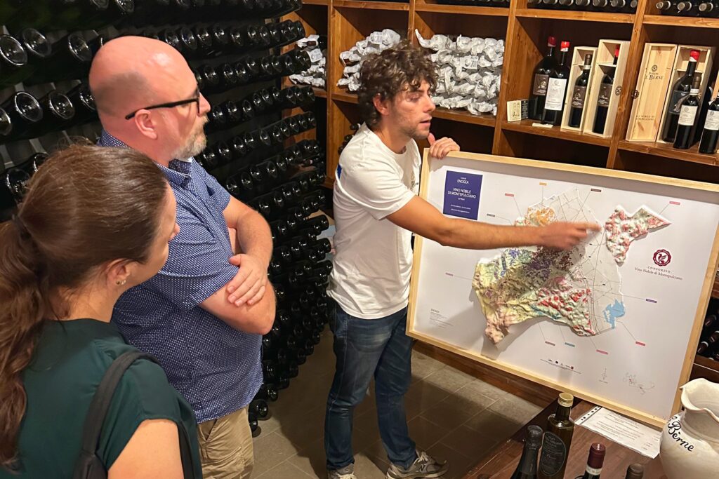 Guests reviewing a Tuscany wine map with their guide during a wine tour from Florence, learning how regions like Montalcino and Bolgheri shape the day’s itinerary.