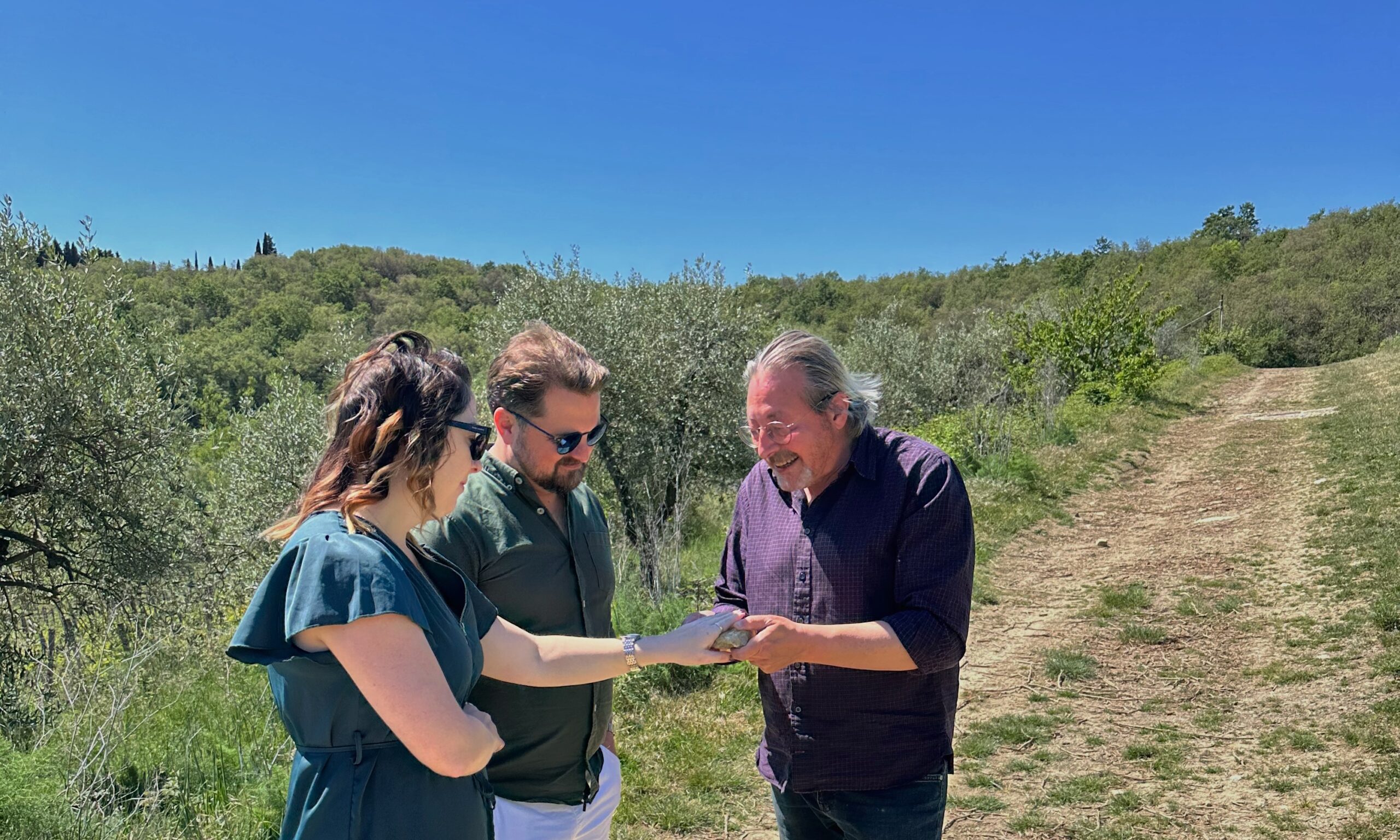 Guests learning about Tuscan terroir and vineyard soils with a local wine expert during a private wine tour in Tuscany.