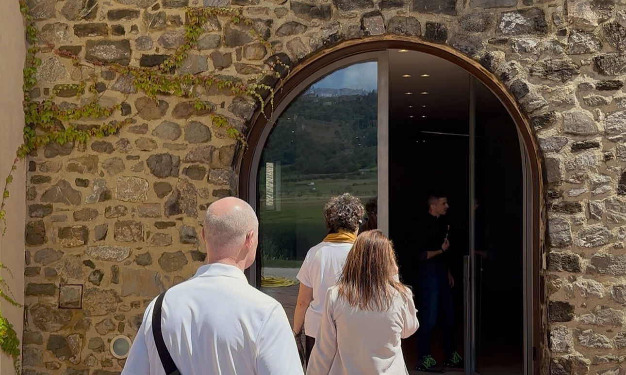 Guests entering a Tuscan winery for a private wine tasting and cellar visit during a wine tour in Tuscany.