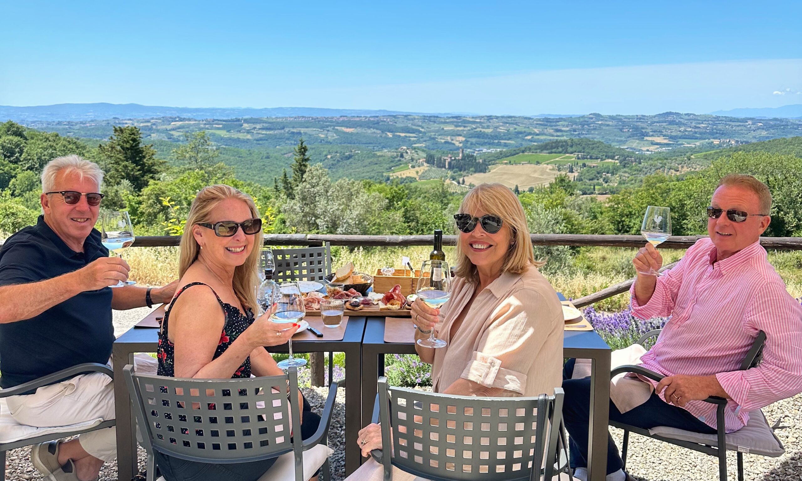 Guests enjoying wine and a relaxed lunch with panoramic vineyard views during a Tuscany wine tour, illustrating why fewer winery stops create a better one-day experience.