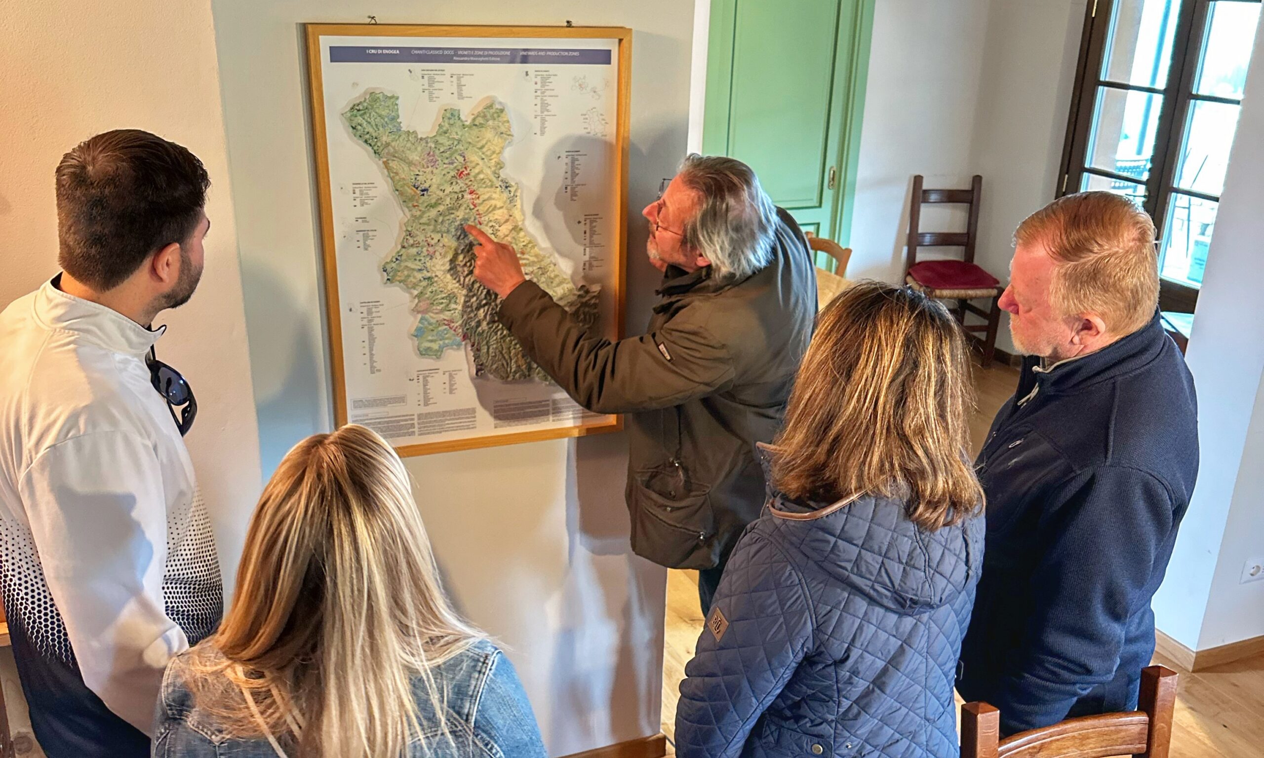 Wine guide explaining the Tuscan wine region to guests during a guided wine tour in Tuscany.