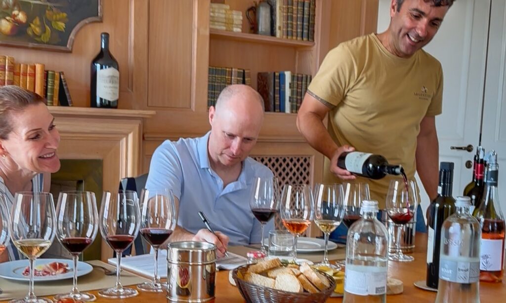 Guests enjoying a structured wine tasting with multiple Tuscan wines during a guided wine tour.